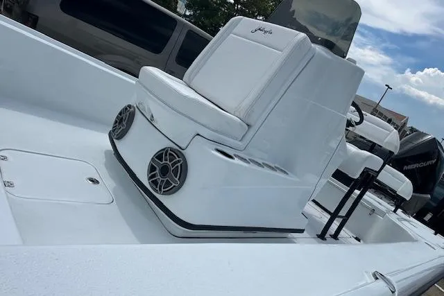 Slide: The Image of 2026 Yellowfin 24 CE boat deck with storage compartments, parked near modern buildings. - 14