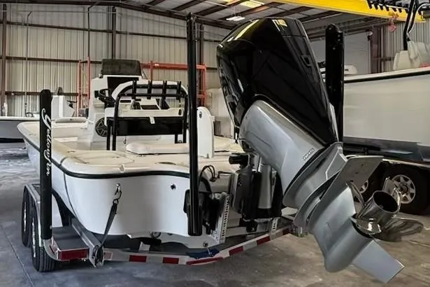 Slide: The Image of 2026 Yellowfin 24 CE boat in a warehouse, featuring a powerful outboard motor. - 17