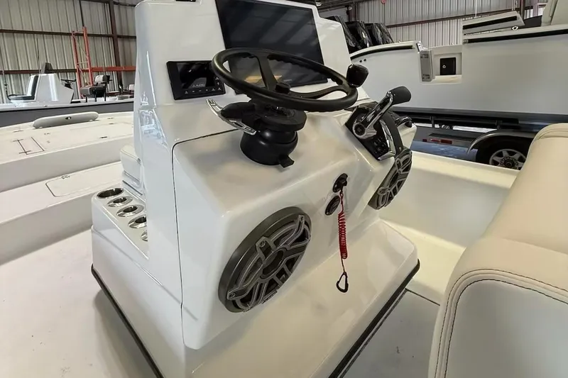 Slide: The Image of 2026 Yellowfin 24 CE boat console with steering wheel and controls in a showroom. - 19