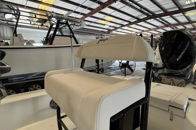 Slide: The Image of 2026 Yellowfin 24 CE boat interior with Mercury engine in a warehouse setting. - 20