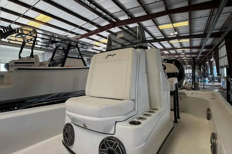 Slide: The Image of 2026 Yellowfin 24 CE boat interior with white seating in a warehouse setting. - 21