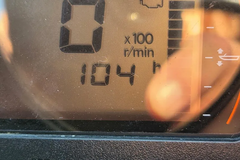 Slide: The Image of Close-up of 2019 Bennington Q 25 QCW dashboard showing 104 hours and RPM gauge. - 10