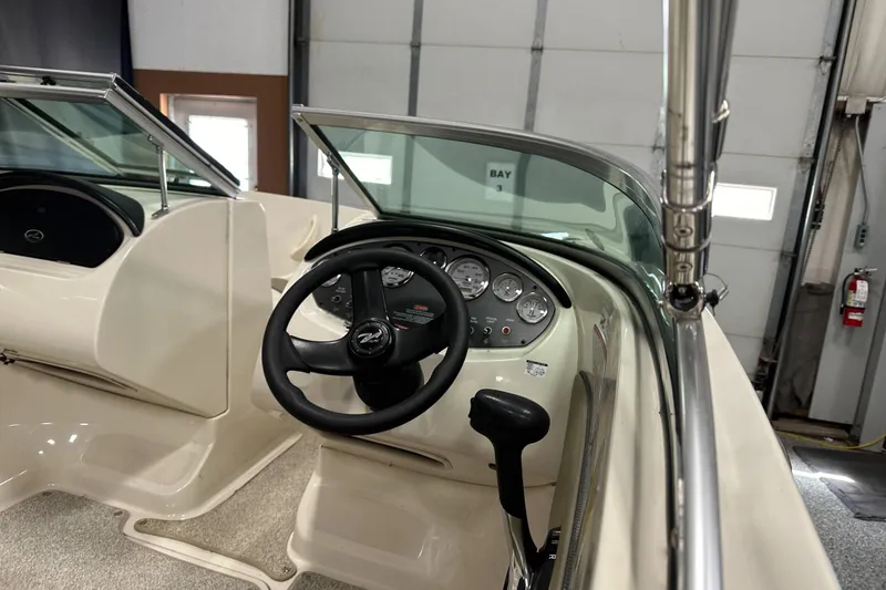 Slide: The Image of 2007 Sea Ray 185 Bow Rider interior with cushioned seating and cup holders. - 13