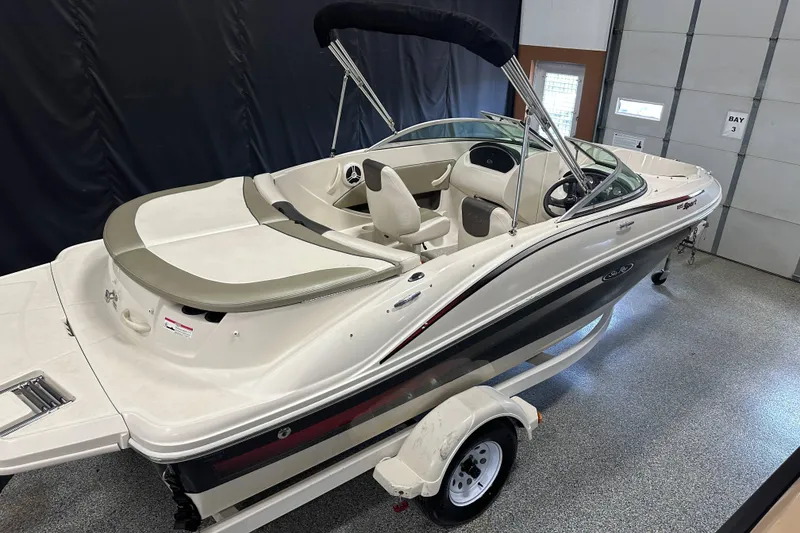 Slide: The Image of 2007 Sea Ray 185 Bow Rider boat in a garage, featuring sleek design and trailer. - 6