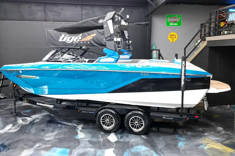 Slide: The Image of 2022 Nautique Super Air Nautique G23 boat in showroom, vibrant blue and white design. - 3