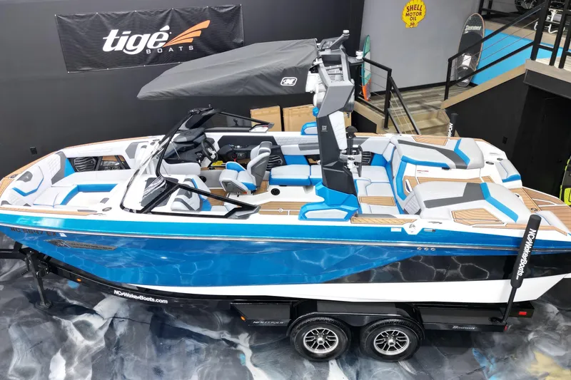 Slide: The Image of 2022 Nautique Super Air Nautique G23 boat, blue and white, displayed indoors on a trailer. - 5