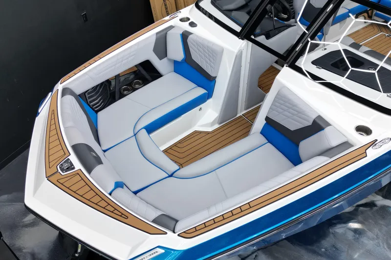 Slide: The Image of 2022 Nautique Super Air Nautique G23 boat interior with blue and white seating, teak flooring. - 8