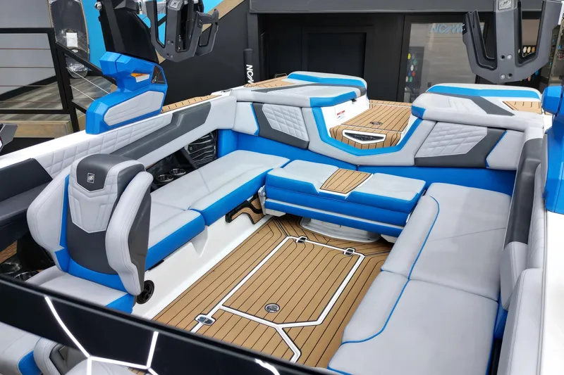 Slide: The Image of 2022 Nautique Super Air Nautique G23 interior with blue and white seating, teak flooring. - 9