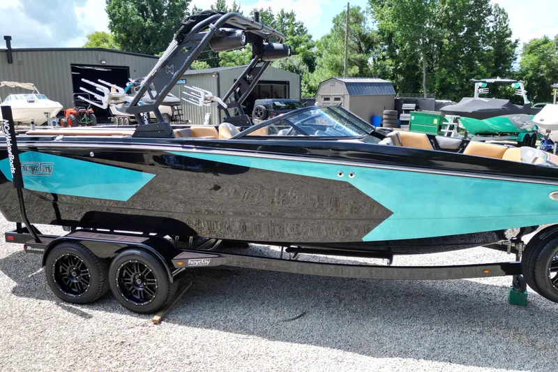 Slide: The Image of 2022 Heyday WTSurf boat with black and turquoise design on a trailer. - 15