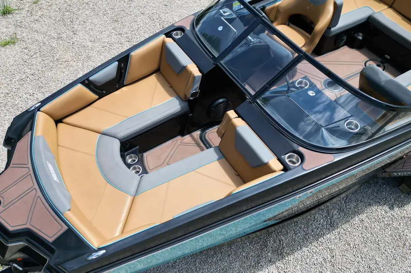Slide: The Image of 2022 Heyday WTSurf boat interior with tan and gray seating, glass windshield, and cup holders. - 5