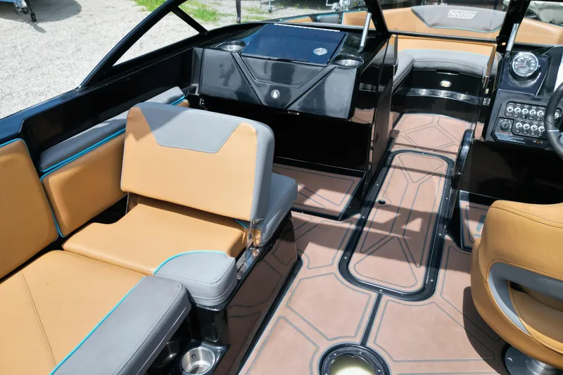 Slide: The Image of 2022 Heyday WTSurf boat interior with tan and gray seating, modern dashboard, and stylish flooring. - 8