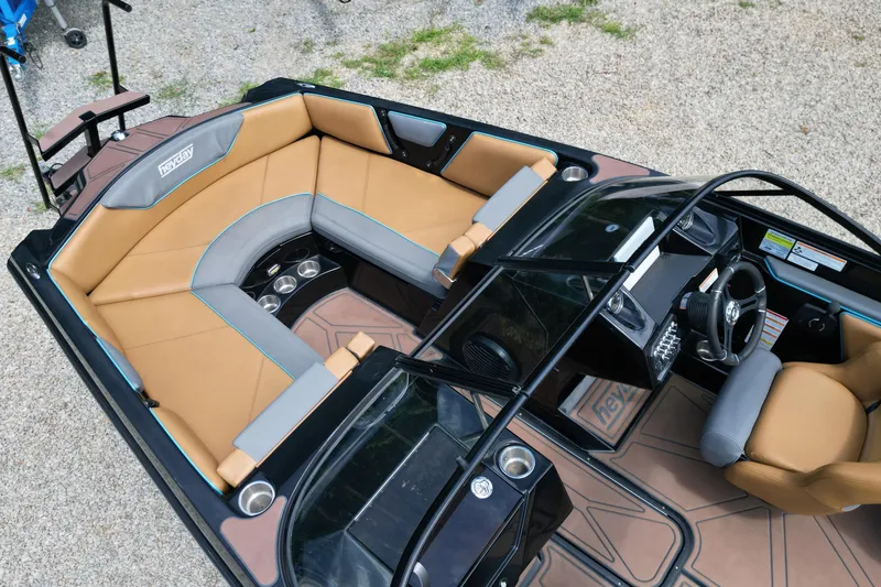 Slide: The Image of 2022 Heyday WTSurf boat interior with tan seating and modern dashboard design. - 4