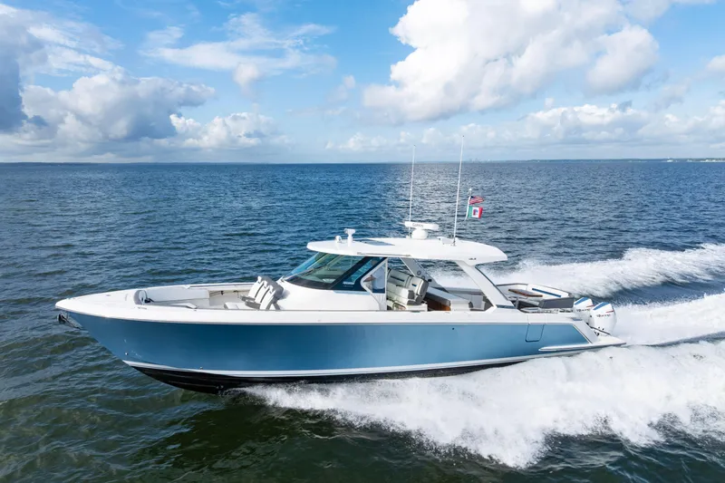 The Image of 2021 Tiara Yachts 43 LS cruising on open water under a clear blue sky. - 0
