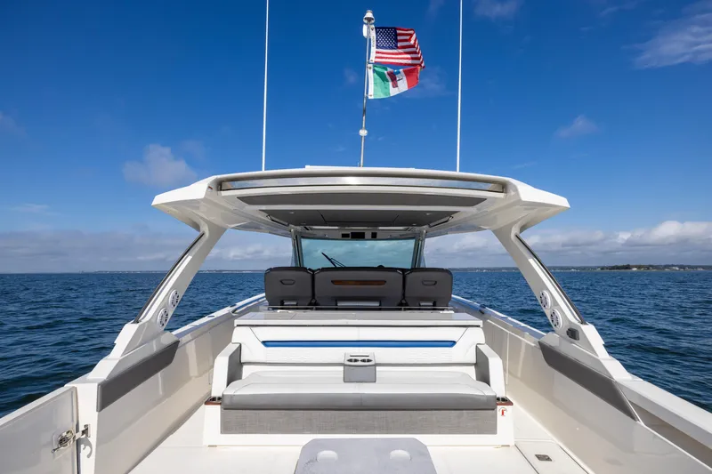 Slide: The Image of 2021 Tiara Yachts 43 LS on open water, featuring spacious deck and dual flags. - 16