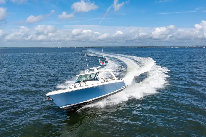 Slide: The Image of 2021 Tiara Yachts 43 LS cruising on open water under a clear blue sky. - 4