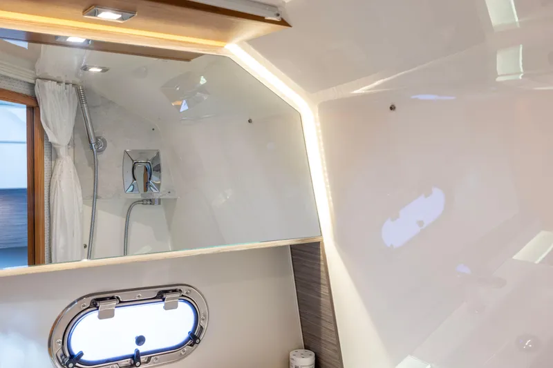 Slide: The Image of Luxurious bathroom interior of 2021 Tiara Yachts 43 LS with modern fixtures and porthole window. - 41
