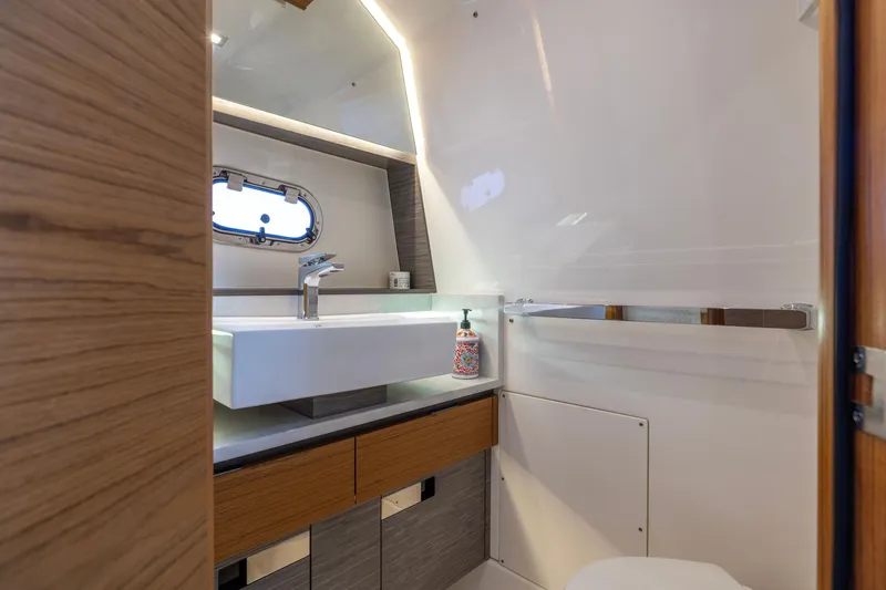 Slide: The Image of Luxurious bathroom interior of 2021 Tiara Yachts 43 LS with modern sink and porthole window. - 42