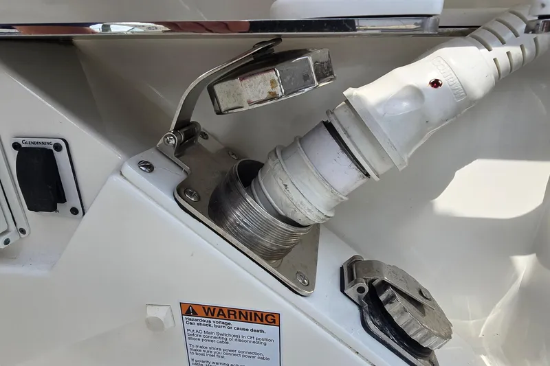 Slide: The Image of Boat power connection on a 2021 Tiara Sport 43 LS, featuring a warning label. - 53