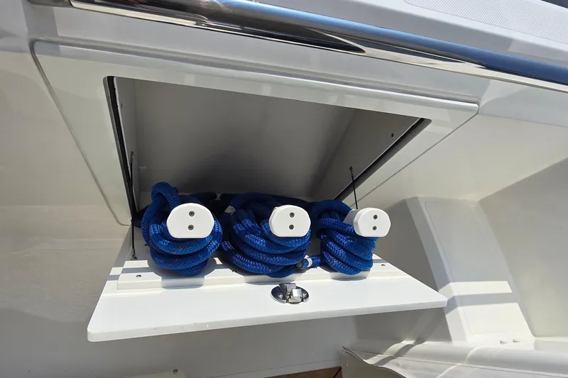 Slide: The Image of Storage compartment with blue ropes on a 2021 Tiara Sport 43 LS boat. - 54