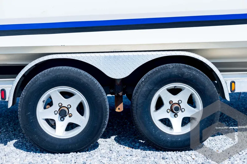 Slide: The Image of Trailer wheels of a 2008 Triton 240 LTS boat on gravel surface. - 13