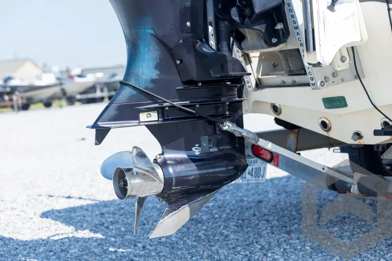 Slide: The Image of 2008 Triton 240 LTS boat motor and propeller on gravel surface. - 17