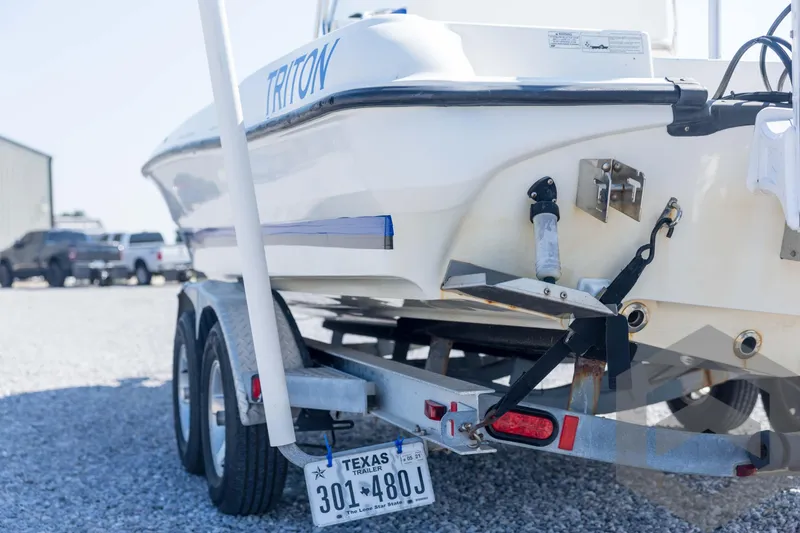 Slide: The Image of 2008 Triton 240 LTS boat on trailer with Texas license plate in parking area. - 23