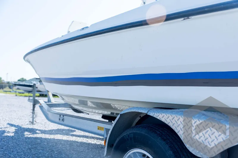 Slide: The Image of 2008 Triton 240 LTS boat on trailer, side view with blue stripe detail. - 26