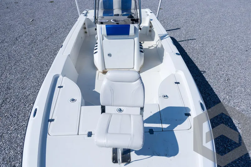 Slide: The Image of 2008 Triton 240 LTS boat interior with white seating and console, on gravel surface. - 27
