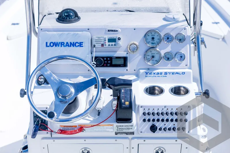 Slide: The Image of 2008 Triton 240 LTS boat dashboard with steering wheel, gauges, and Lowrance electronics. - 39
