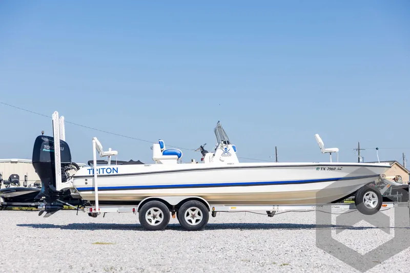 Slide: The Image of 2008 Triton 240 LTS boat on trailer, side view, clear sky background. - 4