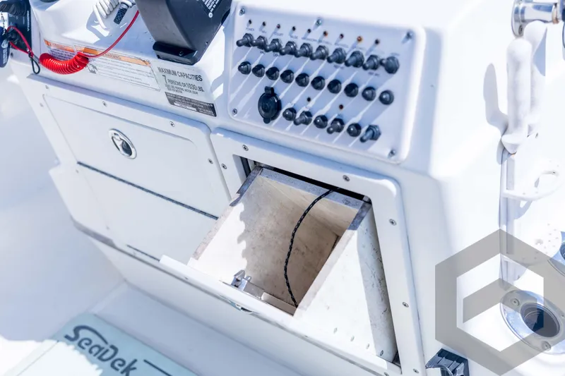 Slide: The Image of 2008 Triton 240 LTS boat console with open storage compartment and control panel. - 47