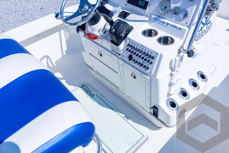 Slide: The Image of 2008 Triton 240 LTS boat cockpit with steering wheel, controls, and blue-striped seating. - 48