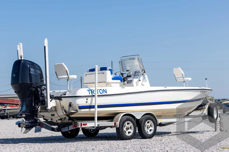 Slide: The Image of 2008 Triton 240 LTS boat on trailer with Tohatsu outboard motor, parked on gravel. - 5