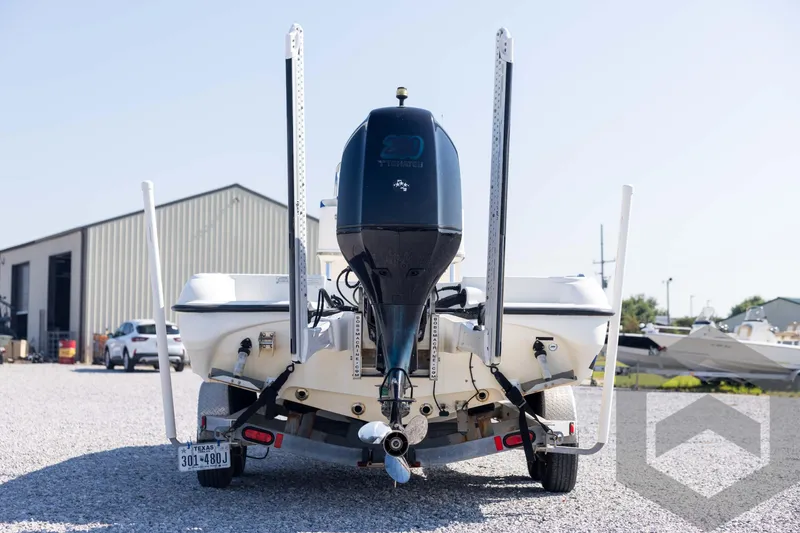 Slide: The Image of 2008 Triton 240 LTS boat on trailer, rear view, parked on gravel lot. - 6