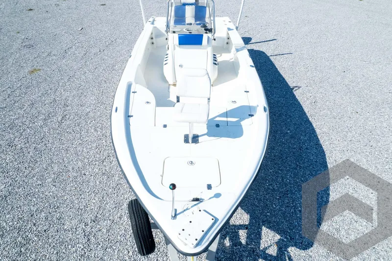 Slide: The Image of 2008 Triton 240 LTS boat on gravel, featuring a sleek white design and spacious deck. - 74