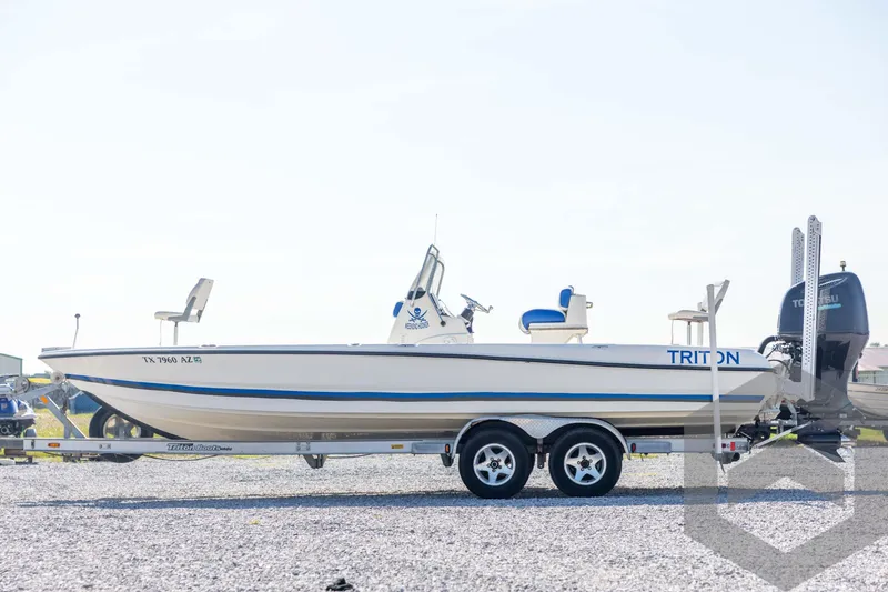 Slide: The Image of 2008 Triton 240 LTS boat on trailer, side view, outdoors on gravel. - 8