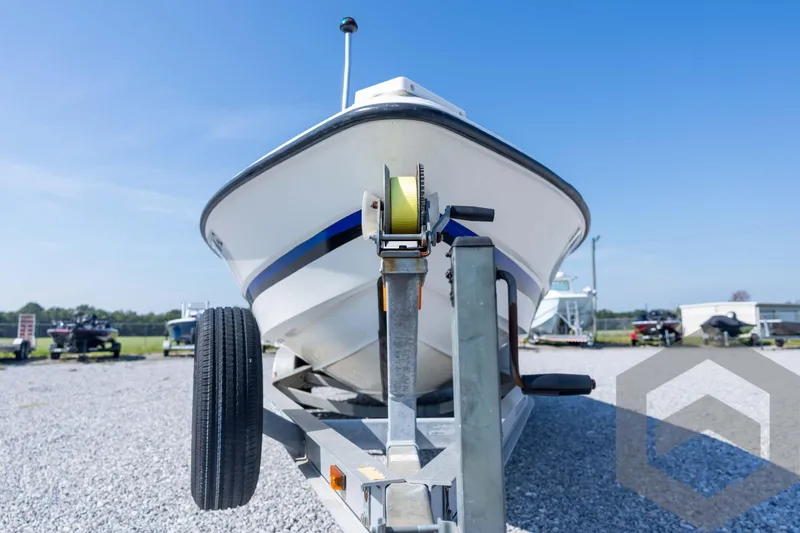 Slide: The Image of 2008 Triton 240 LTS boat on trailer, parked on gravel lot under clear blue sky. - 9