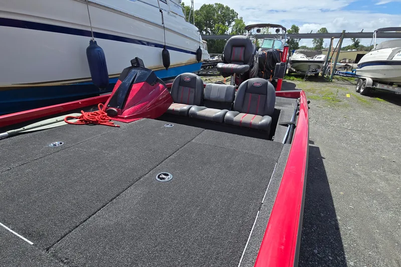 Slide: The Image of 2013 Ranger RT188 boat with red accents, parked in a marina. - 13
