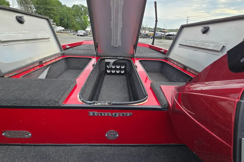 Slide: The Image of 2013 Ranger RT188 boat interior with open storage compartments and red finish. - 17