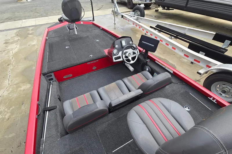 Slide: The Image of 2013 Ranger RT188 boat interior with steering console and seating, parked on a trailer. - 8