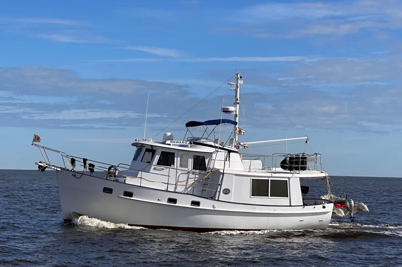 The Image of 1994 Kadey-Krogen Krogen 42 yacht cruising on open water under a clear blue sky. - 0