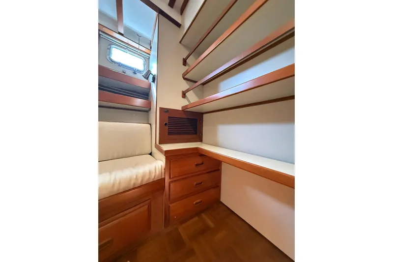 Slide: The Image of 1994 Kadey-Krogen Krogen 42 interior with wooden shelves and drawers, featuring a cozy seating area. - 19