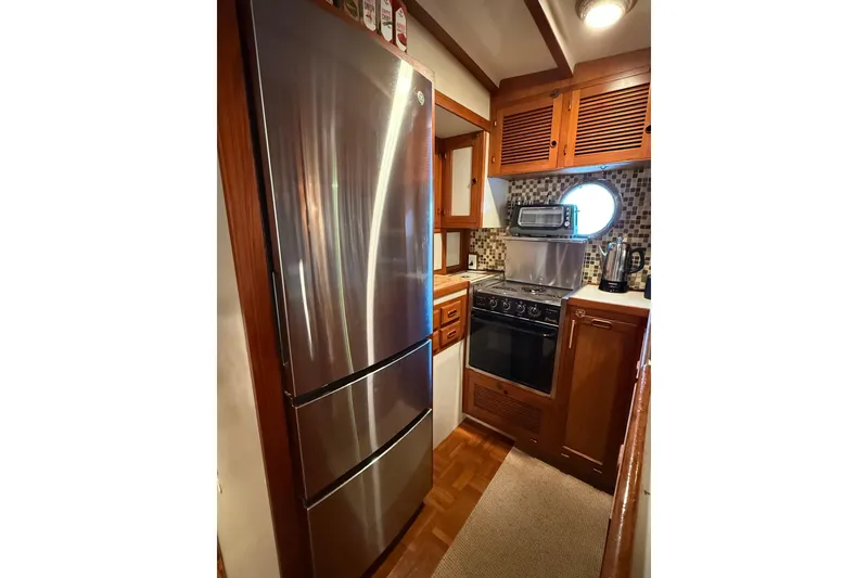 Slide: The Image of Compact galley kitchen in 1994 Kadey-Krogen Krogen 42 yacht with stainless steel appliances. - 4