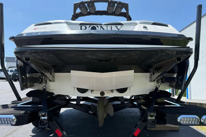 Slide: The Image of 2014 Axis A22 boat rear view with trailer, showcasing propeller and wakeboard tower. - 10
