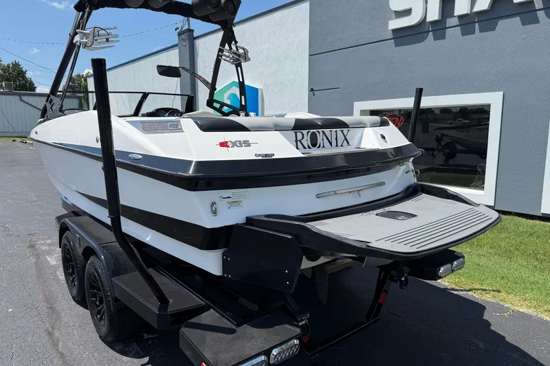 Slide: The Image of 2014 Axis A22 boat on trailer, parked outside a building. - 11