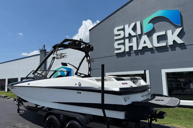 Slide: The Image of 2014 Axis A22 boat parked outside Ski Shack dealership under clear blue sky. - 12