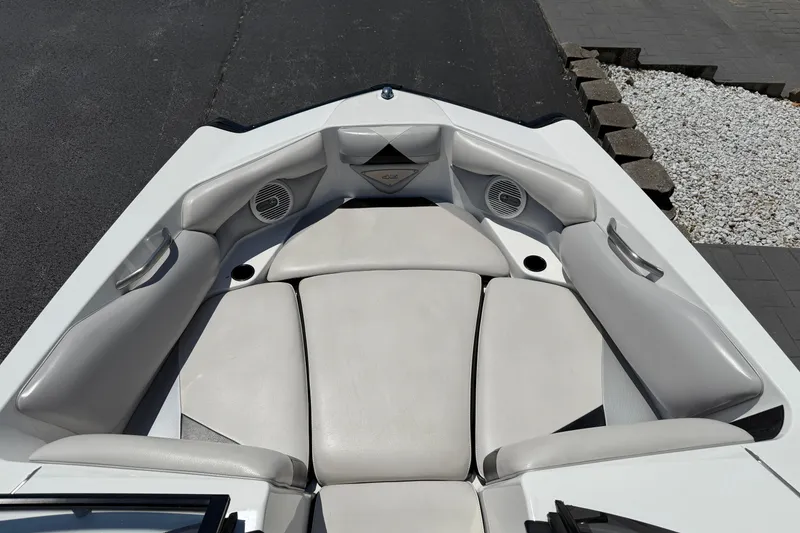 Slide: The Image of 2014 Axis A22 boat interior with cushioned seating and built-in speakers. - 23