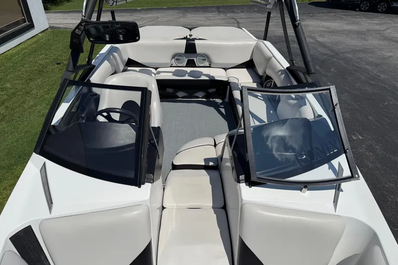 Slide: The Image of 2014 Axis A22 boat interior with open windshield and seating arrangement. - 25