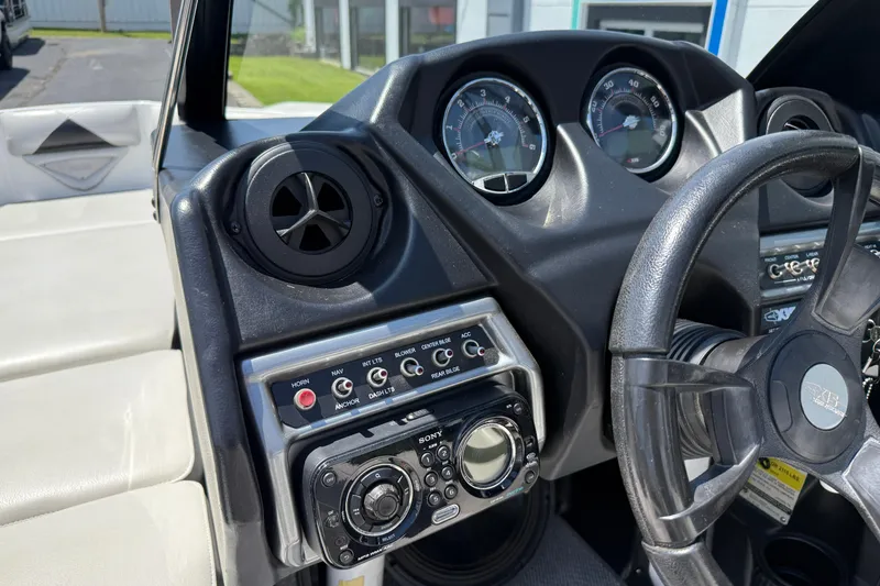 Slide: The Image of 2014 Axis A22 boat dashboard with steering wheel and control panel. - 28