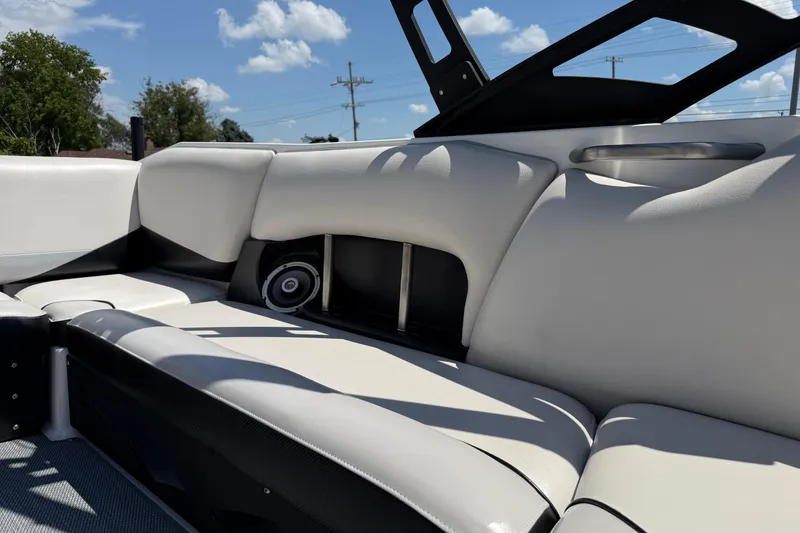 Slide: The Image of 2014 Axis A22 boat interior with white leather seats and speaker, under blue sky. - 30
